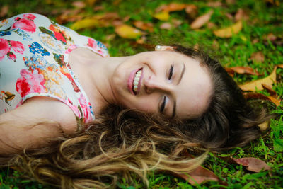 Smiling woman lying down on field