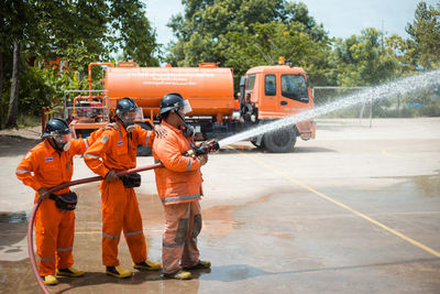 Rear view of people working on road