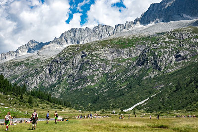 People hiking against mountains during winter