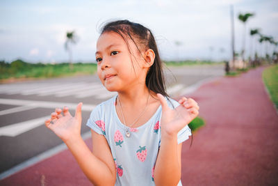 Portrait of young woman standing against sky