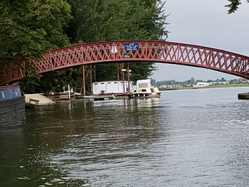 Arch bridge over river against sky