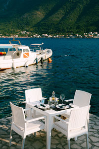 Table and chairs arranged by sea