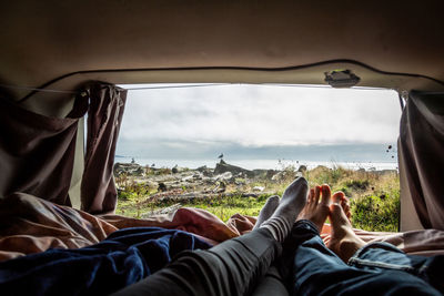 Low section of couple relaxing in camper van