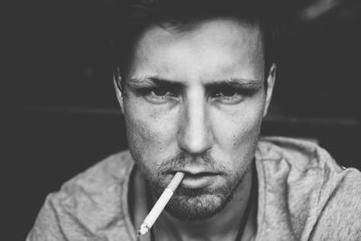 Close-up portrait of man smoking cigarette