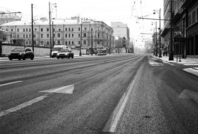 Cars on road in city against sky