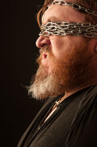 Portrait of man wearing hat against black background