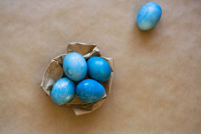 High angle view of multi colored eggs on paper