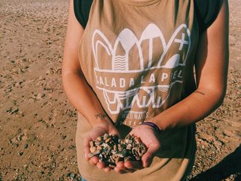 Midsection of woman holding fruit while standing on land