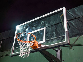 Low angle view of basketball hoop against window