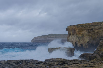 Scenic view of waterfall against sky