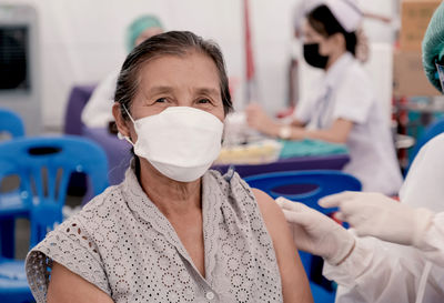 Portrait of woman wearing mask getting vaccinated