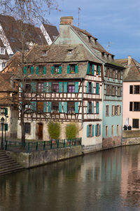 Buildings by canal against sky