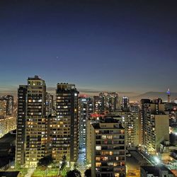 High angle view of illuminated buildings against sky at night