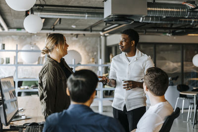 Male and female computer programmers discussing ideas at office