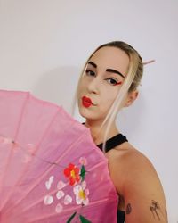 Portrait of a beautiful young woman standing against wall