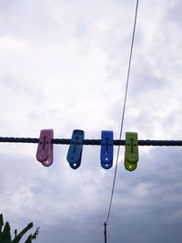 Low angle view of lighting equipment hanging against sky