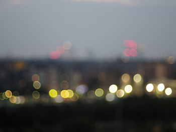 Defocused image of illuminated lights in sea at night