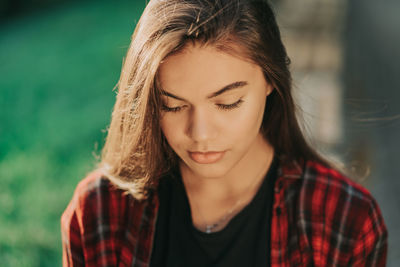 Close-up portrait of young woman looking down