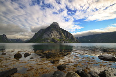 Scenic view of lake and mountains against cloudy sky