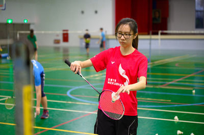 Woman practicing badminton at sports court