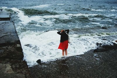 Rear view of woman photographing sea