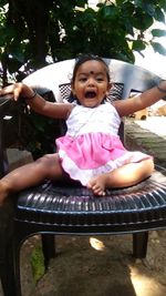 Portrait of a smiling girl sitting outdoors