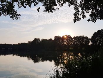 Scenic view of lake against sky at sunset