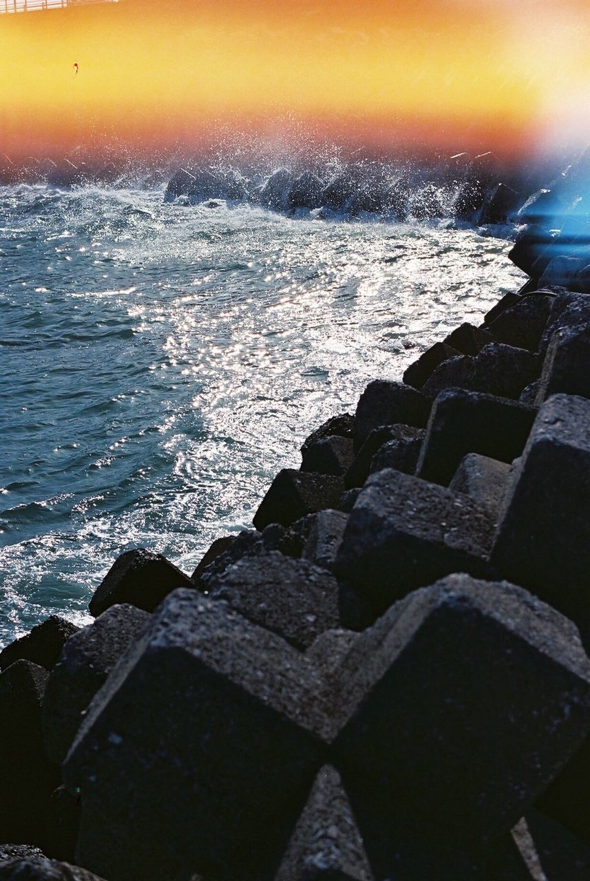 water, sunset, sea, scenics, rock - object, sun, beauty in nature, tranquil scene, horizon over water, tranquility, orange color, nature, idyllic, sky, wave, sunlight, shore, outdoors, rock formation, no people