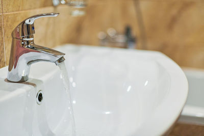 Faucet in bathroom interior. opened water tap for washing hands from dirt. sanitary prevention