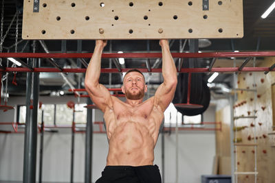 Shirtless man exercising at gym