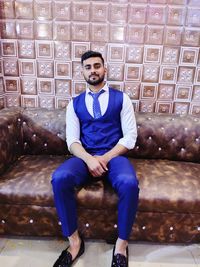 Portrait of young man sitting on sofa