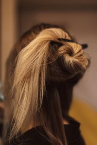 Female hairstyle preparation on blonde long hair. back view. backstage prepare