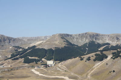 Scenic view of landscape and mountains against clear blue sky