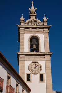 Low angle view of clock tower against clear blue sky