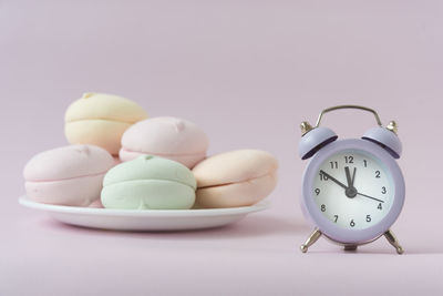 Close-up of clock on table against white background