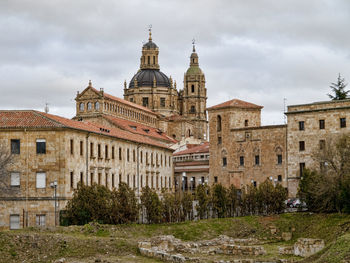 Buildings in city against cloudy sky