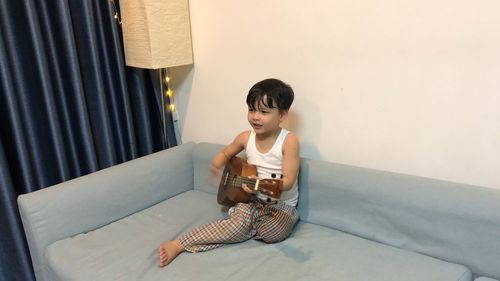 Boy playing on bed at home