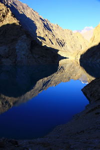 Scenic view of lake and mountains against blue sky