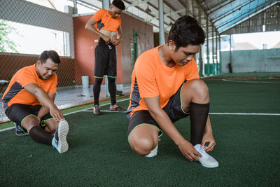 Soccer players stretching in football field