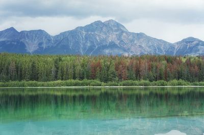 Scenic view of lake by mountains against sky