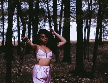 Portrait of young woman standing in forest