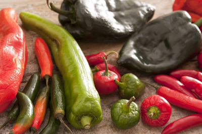 Various chili peppers and bell pepper on table