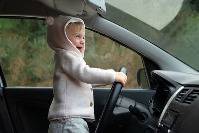 Portrait of young woman sitting in car