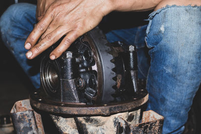 Low section of man repairing machinery