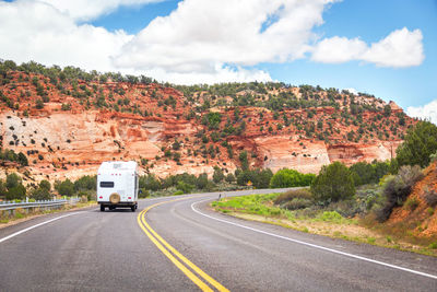 Road by mountain against sky