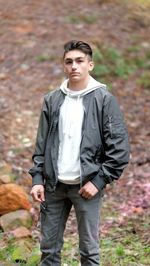 Portrait of young man standing in forest