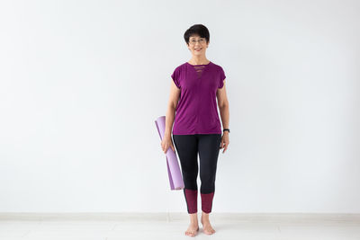 Portrait of woman standing against wall