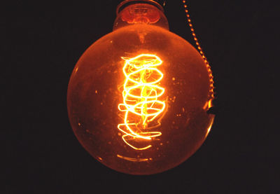 Close-up of lit candle in dark room