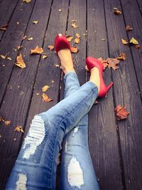 Low section of woman sitting on wood