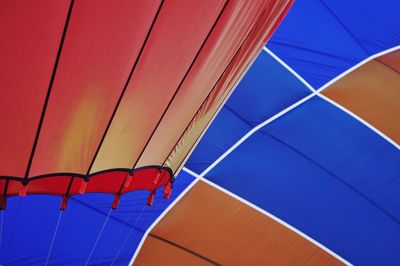 Low angle view of multi colored umbrella against blue sky